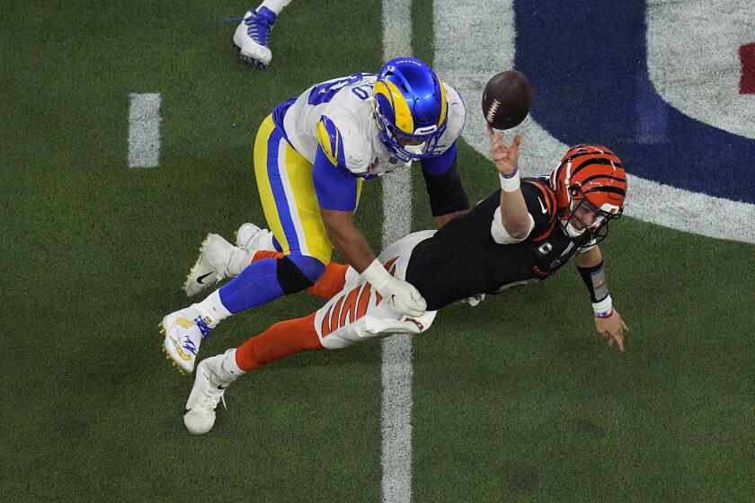 FILE - Los Angeles Rams defensive end Aaron Donald (99) forces Cincinnati Bengals quarterback Joe Burrow (9) to throw an incomplete pass during the second half of the NFL Super Bowl 56 football game Sunday, Feb. 13, 2022, in Inglewood, Calif. The Bengals and Rams are set for a rematch for the first time in a regular season game since the Super Bowl. (AP Photo/Matt Rourke, File)