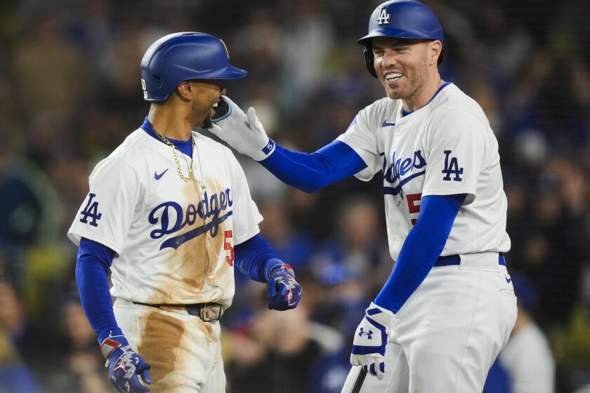 Los Angeles Dodgers' Mookie Betts, left, celebrates his home run against the San Francisco Giants with Freddie Freeman during the third inning of a baseball game Tuesday, April 2, 2024, in Los Angeles. (AP Photo/Ryan Sun)
