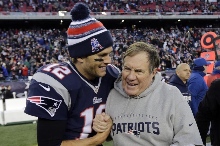 New England Patriots quarterback Tom Brady, left, celebrates with Coach Bill Belichick after a win over the Miami Dolphins on Dec. 14. Will the duo win their fourth Super Bowl together on Sunday?