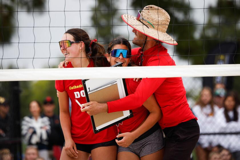 San Diego, CA - May 04: Cathedral Catholic's Kai Welsh (21) and Bella Ayers (9) celebrate with assistant coach Chris Law after their match against Torrey Pines during the CIF San Diego Section beach volleyball Open Division championship at Miramar College on Saturday, May 4, 2024 in San Diego, CA. (Meg McLaughlin / The San Diego Union-Tribune)