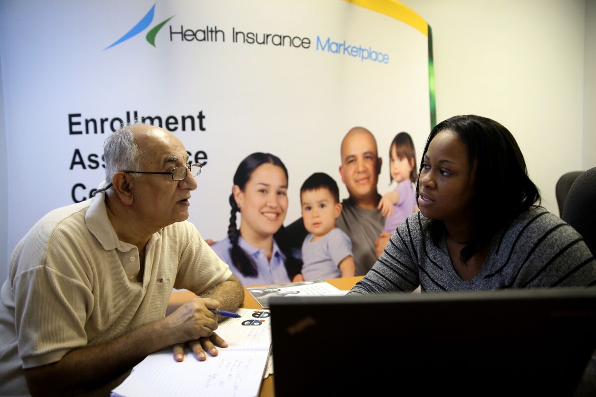 An Obamacare enrollment specialist helps a man sign up for health insurance through the Affordable Care Act in Miami in December.