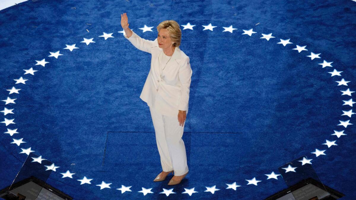 Democratic nominee for president Hillary Clinton waves to the crowd at the Democratic National Convention in Philadelphia on July 28, 2016. For the occasion, she chose a white pantsuit by American designer Ralph Lauren.