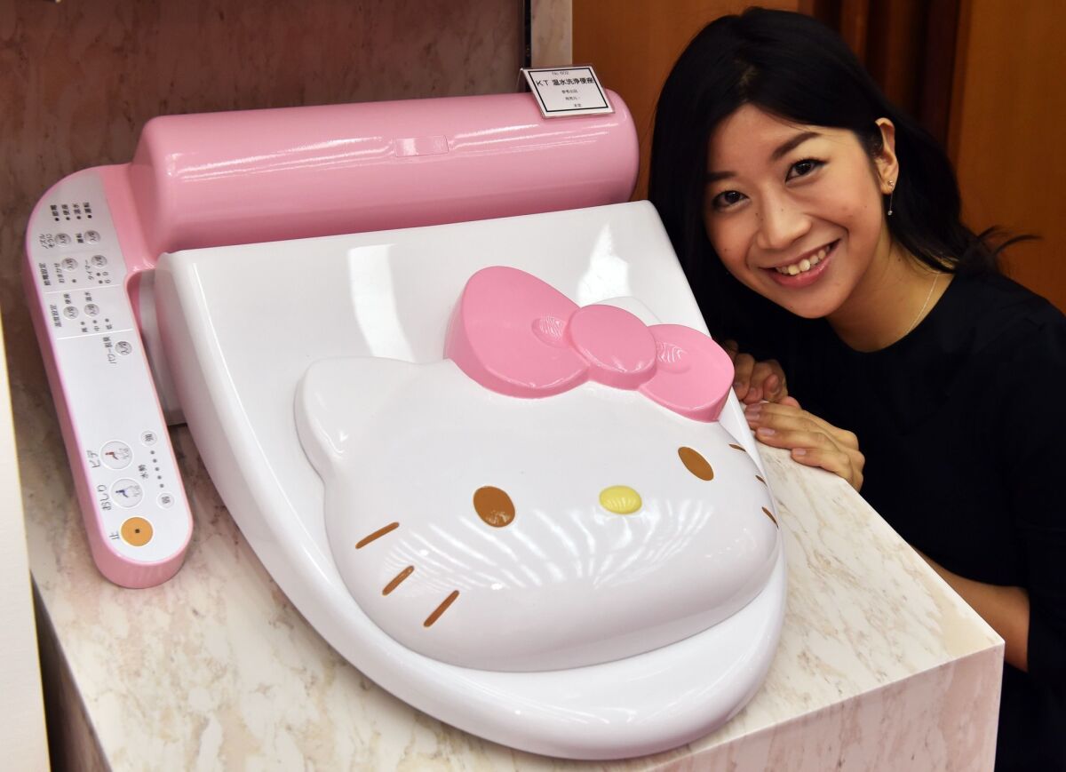 An employee of Japanese character goods maker Sanrio displays a prototype model of a Hello Kitty branded toilet seat.