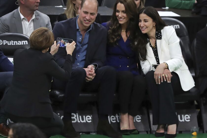 Massachusetts Gov.-Elect Maura Healey takes a photo of Britain's William and Kate, Princess of Wales, and Emilia Fazzalari, wife of Boston Celtics owner Wyc Grousbeck during a timeout in an NBA basketball game between the Boston Celtics and the Miami Heat in Boston, Wednesday, Nov. 30, 2022. (Jim Davis/The Boston Globe vai AP, Pool)
