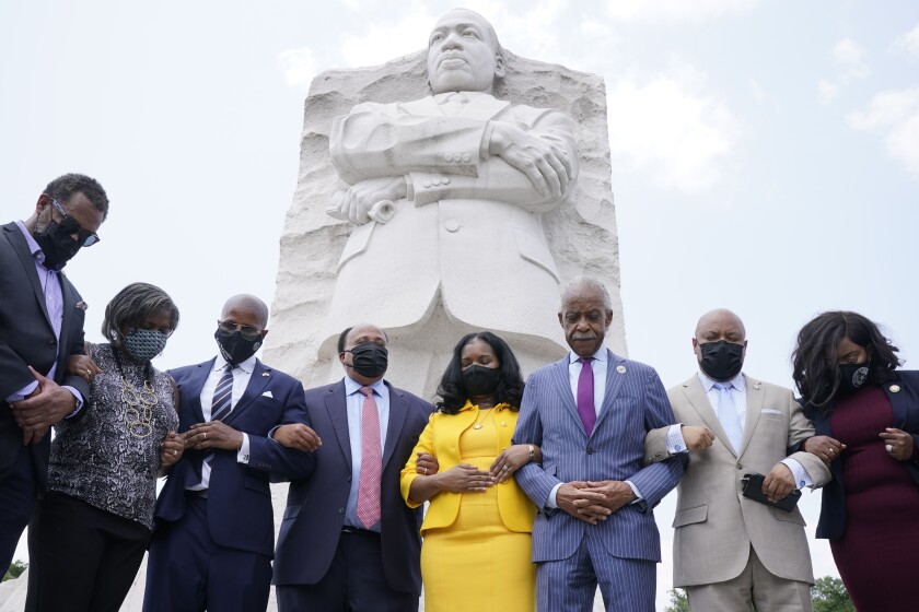 The Rev. Al Sharpton prays at the Martin Luther King Jr. Memorial in Washington.