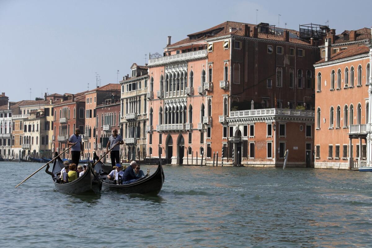 Visitors tour the Grand Canal by gondola in Venice, Italy.