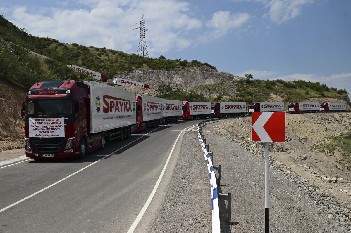 A long line of trucks sit on highway