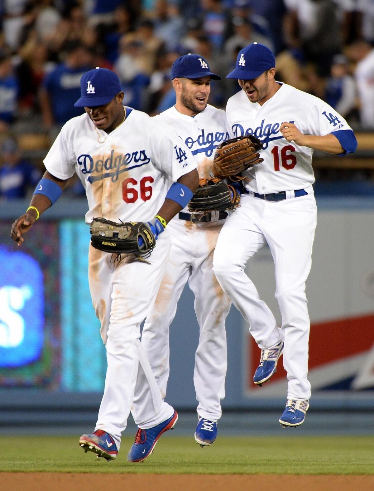Dodgers outfielders Yasiel Puig, left, Skip Schumaker and Andre Ethier celebrate following the team's 4-1 victory over the Cincinnati Reds on Saturday.