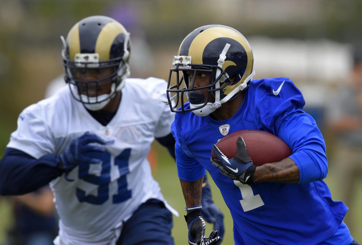 Rams wide receiver Tavon Austin, right, carries the ball as defensive tackle Dominique Easley gives chase during an organized team activity June 1.