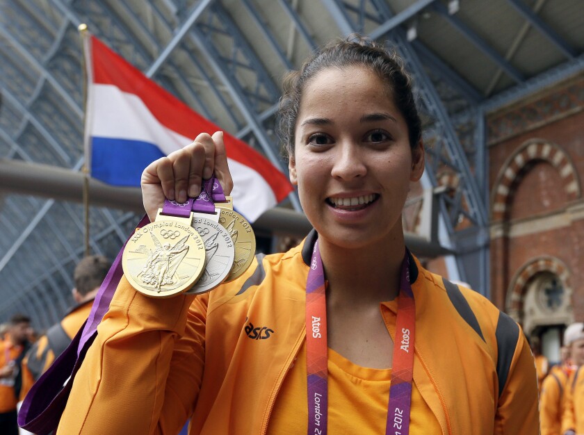 FILE - Swimmer Ranomi Kromowidjojo of the Netherlands displays her two gold and one silver medals as she waits for a train, at St Pancras station, after the 2012 Summer Olympics, in London, Aug. 13, 2012. Three-time Olympic champion swimmer Ranomi Kromowidjojo announced her retirement Thursday Jan. 27, 2022, bringing to an end a career that saw her compete at four Summer Games. (AP Photo/Kirsty Wigglesworth, File)