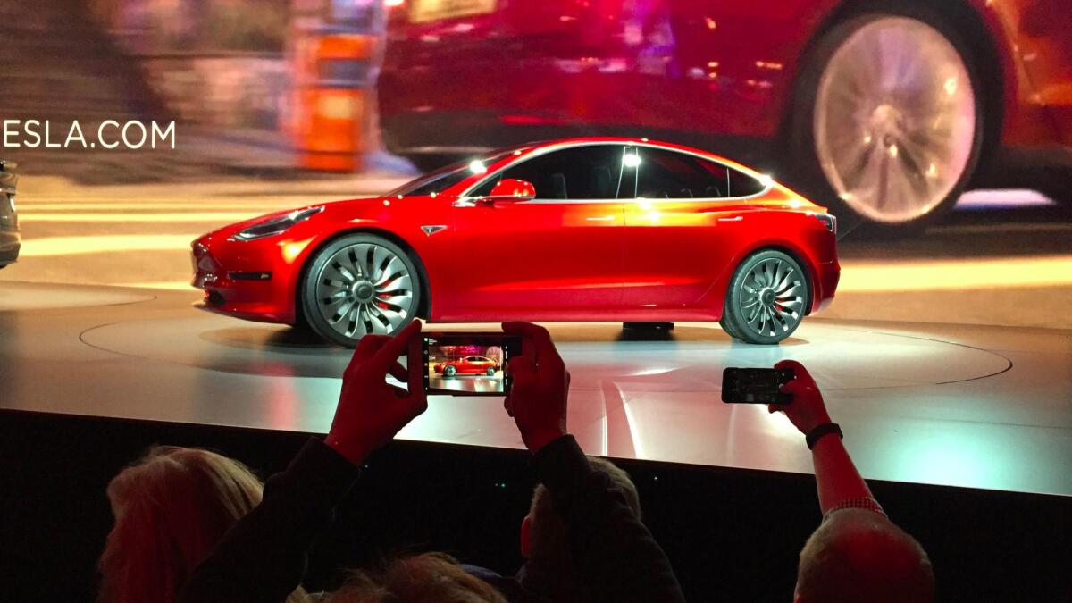 Fans photograph a prototype unveiled at the last Model 3 stage show in March, 2016.
