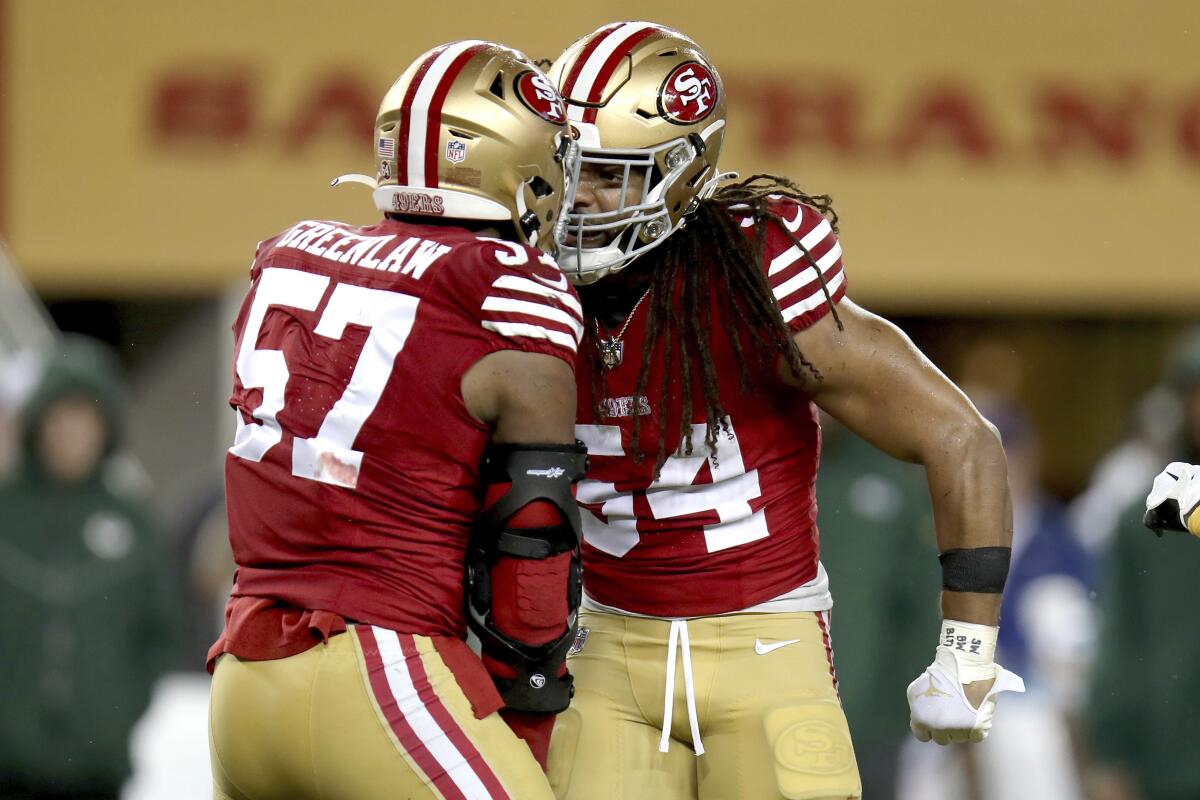San Francisco 49ers linebackers Fred Warner (54) and Dre Greenlaw (57) celebrate a defensive play.