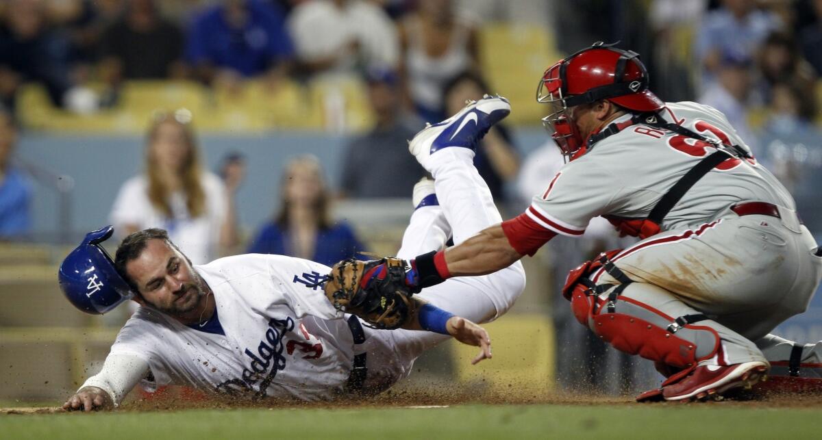 Dodgers outfielder Scott Van Slyke, left, is tagged out at home plate by Philadelphia Phillies catcher Carlos Ruiz during the sixth inning of the Dodgers' 16-1 loss Friday.