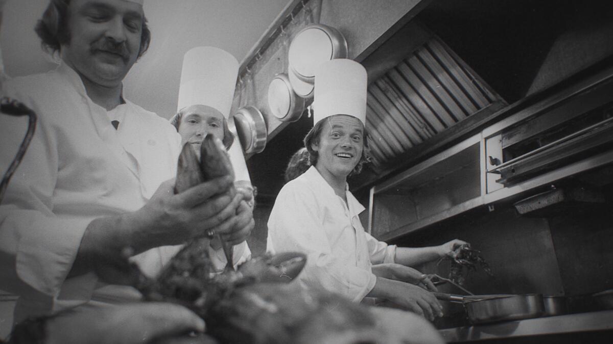 A black-and-white shot from the documentary shows Puck in his early days as a chef.