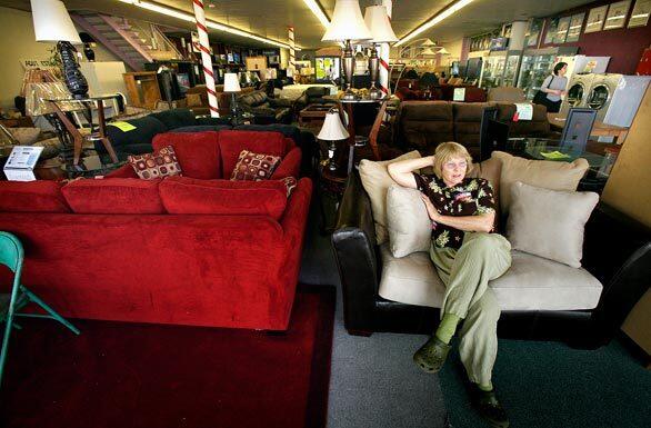 Polling place inspector Katy Croshier takes advantage of the locale and relaxes in a love seat while awaiting voters inside La Popular Furniture on Sunset Boulevard in Echo Park. Croshier said that the day had been slow but that she expected more voters to arrive after the end of the workday.
