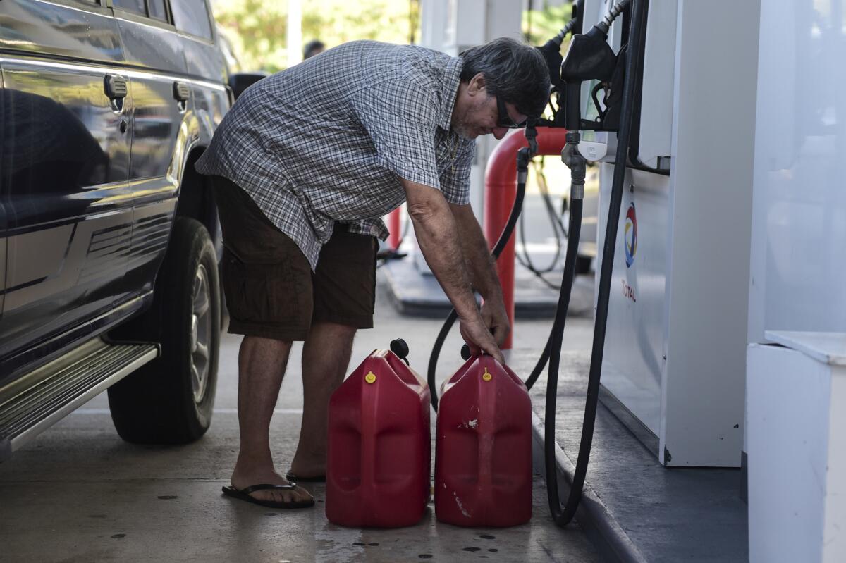 Edgardo Colon picks up his gas container after filling it with diesel for his generator on Thursday in San Juan, Puerto Rico.