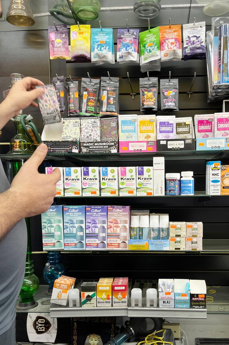 A clerk shows off the wide array of mushroom products available for purchase at a smoke shop in San Diego.