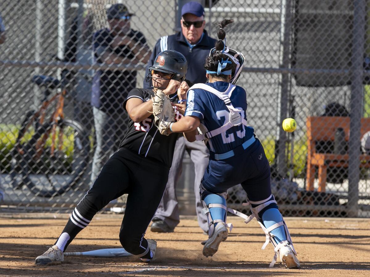 Huntington Beach's Tea Gutierrez collides with Marina's Gabby DiBenedetto, scoring a run during a Surf League game on Friday.