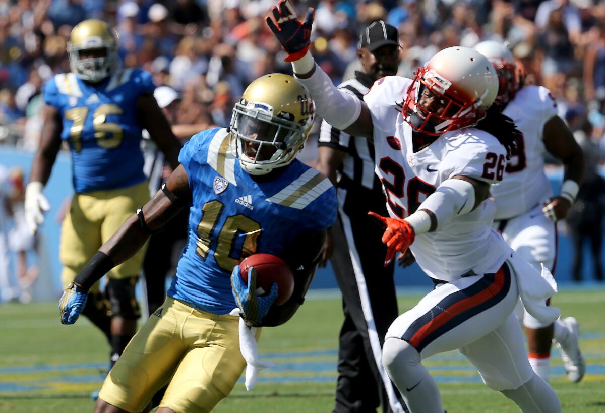 UCLA wide receiver Kenneth Walker III pulls down a pass in front of Virginia cornerback Maurice Canady on Sept. 5.