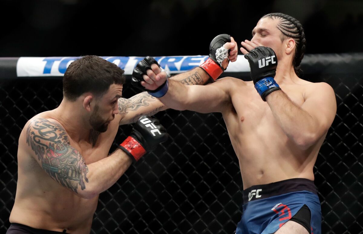 Frankie Edgar, left, and Brian Ortega fight during their featherweight bout during UFC 222 on March 3 in Las Vegas. Ortega won by TKO.