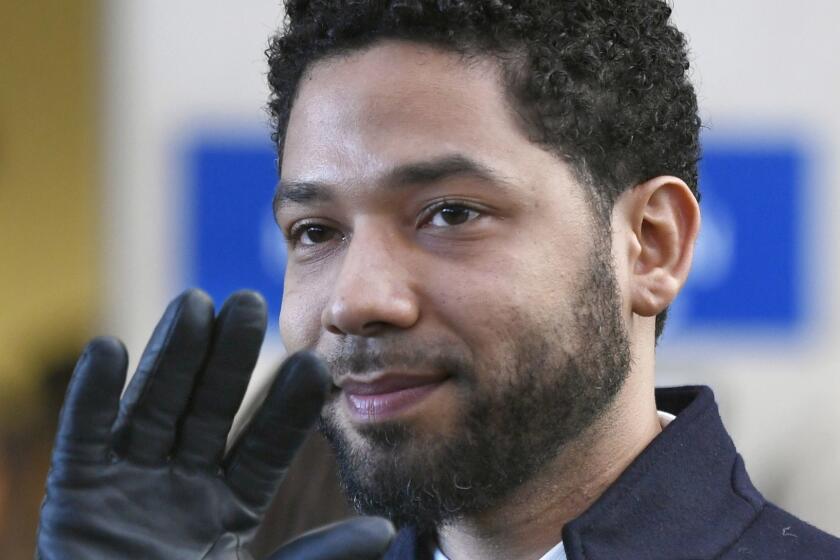 FILE - In this March 26, 2019, file photo, actor Jussie Smollett smiles and waves to supporters before leaving Cook County Court after his charges were dropped in Chicago. Mark Geragos an attorney is warning that if Chicago sues Jussie Smollett for the cost of the investigation into his claim that he was attacked, he'll demand sworn testimony from Mayor Rahm Emanuel, the police chief and others.(AP Photo/Paul Beaty, File)