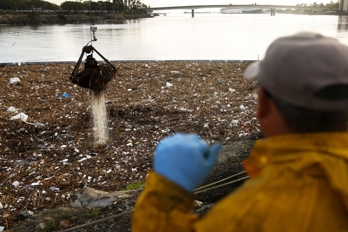 Bitelio Ramirez looks out Thursday over trash that has piled up near the mouth of the Los Angeles River after two days of heavy rain. A worker on the scene said two cranes were being used to lift out about 300 tons of trash.