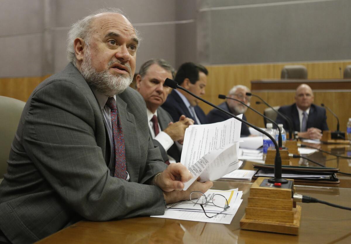 Commissioner Mike Florio of the California Public Utilities Commission, left, talks during an informational hearing at the Capitol in Sacramento on July 10, 2013. California residents will see their electricity bills increase under a new rate structure passed Friday by state regulators.