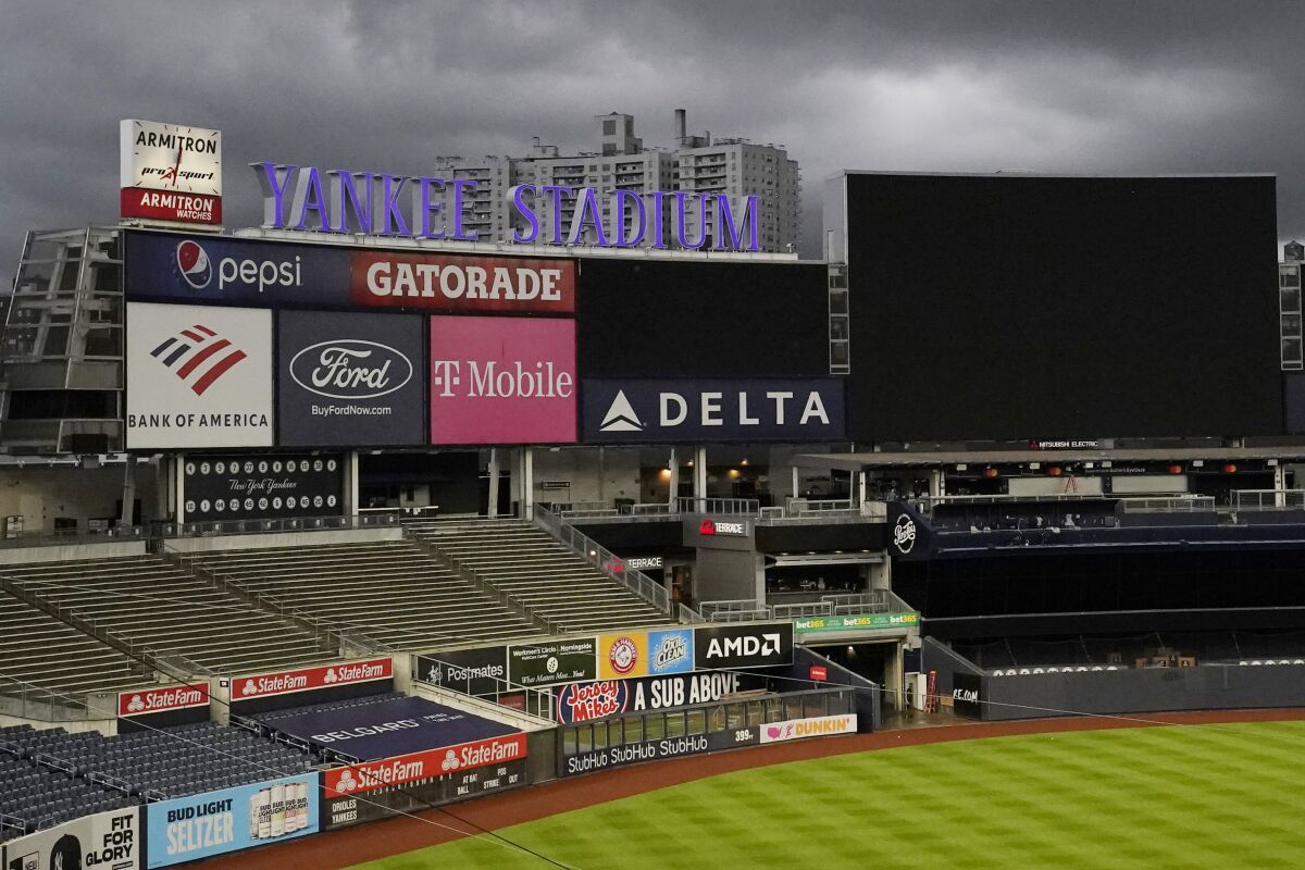 Dark clouds move beyond the empty stands and outfield at Yankee Stadium where a baseball game between the New York Yankees and the Baltimore Orioles was postponed, Thursday, Sept. 10, 2020, in New York. The game was rescheduled for Friday before the scheduled night game between the two teams. (AP Photo/Kathy Willens)