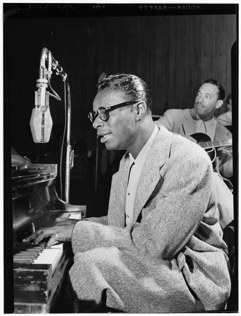 A man plays the piano in a recording studio.