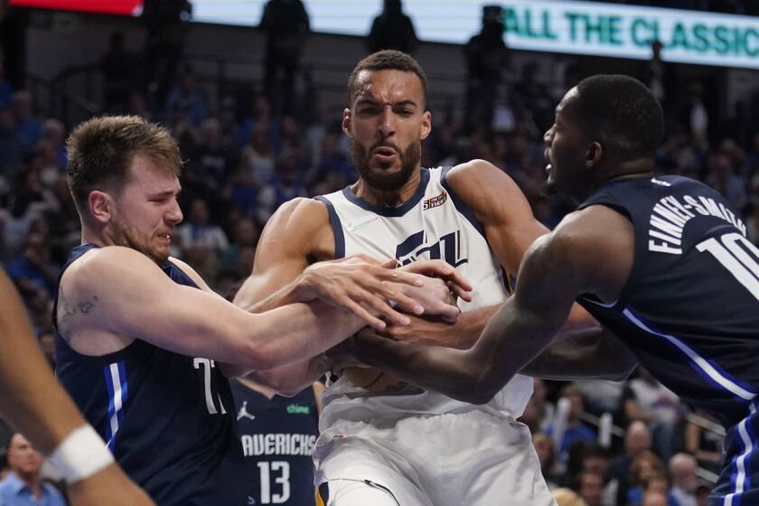 Utah Jazz center Rudy Gobert, center, struggle with Dallas Mavericks guard Luka Doncic, left, and forward Dorian Finney-Smith, right for control of the ball during the second half of Game 5 of an NBA basketball first-round playoff series, Monday, April 25, 2022, in Dallas. (AP Photo/Tony Gutierrez)