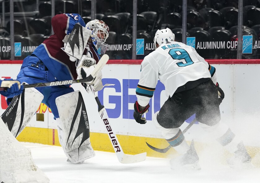 Colorado Avalanche goaltender Devan Dubnyk, left, clears the puck as San Jose Sharks left wing Evander Kane pursues in the first period of an NHL hockey game Saturday, May 1, 2021, in Denver. (AP Photo/David Zalubowski)