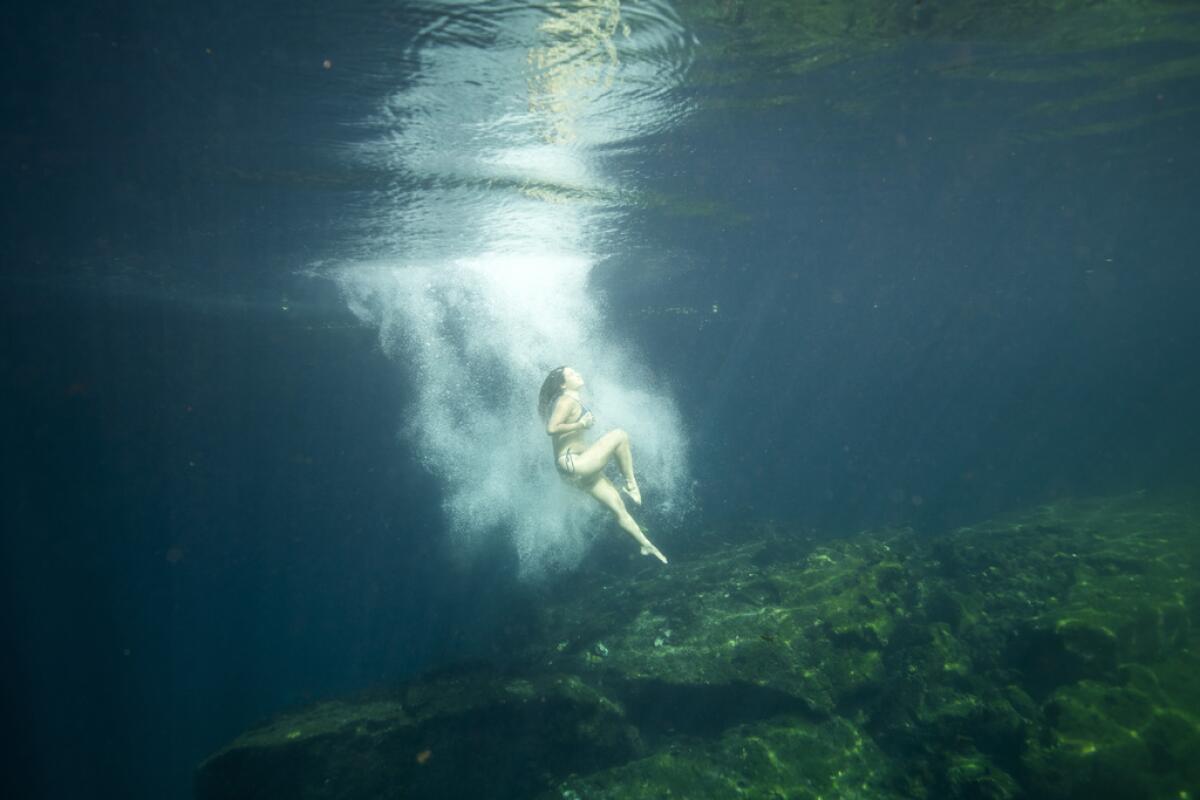 Una turista se sumerge en el cenote "Jardín del Edén"