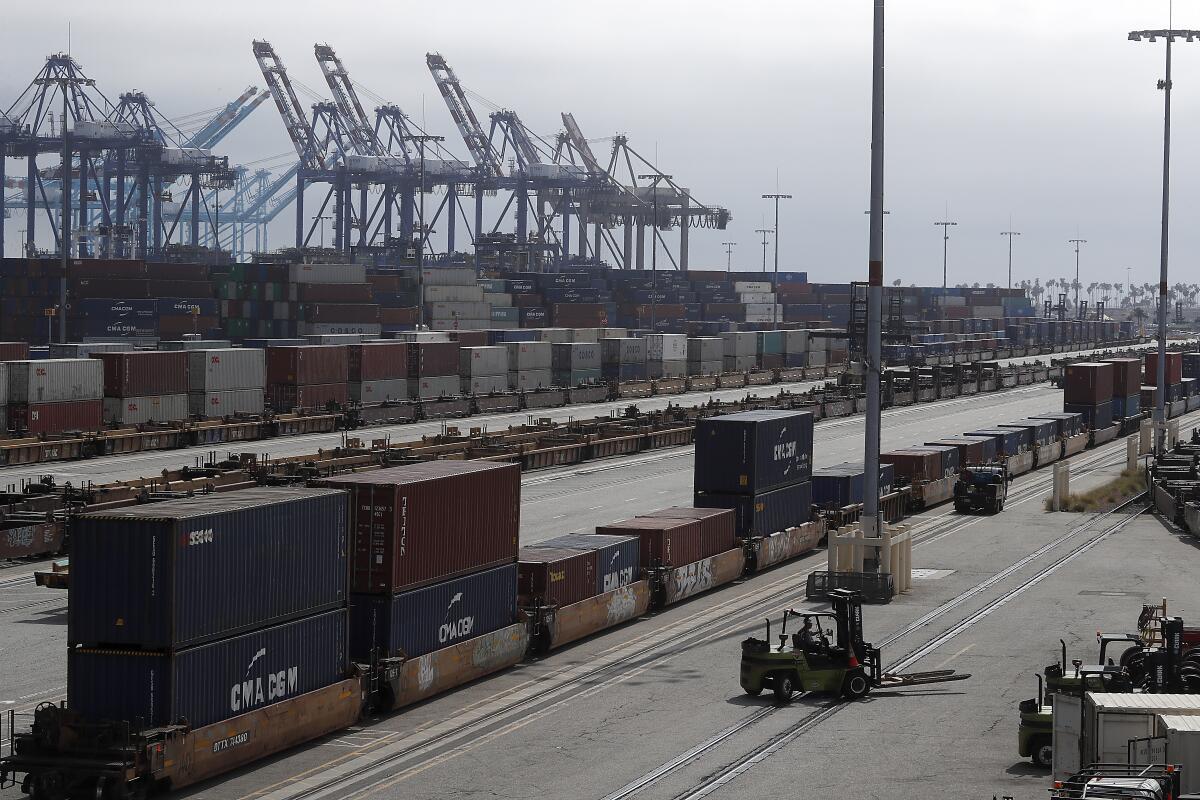 Cargo containers sit on rail lines as more containers wait to be loaded onto ships and trains at the Port of Los Angeles. 