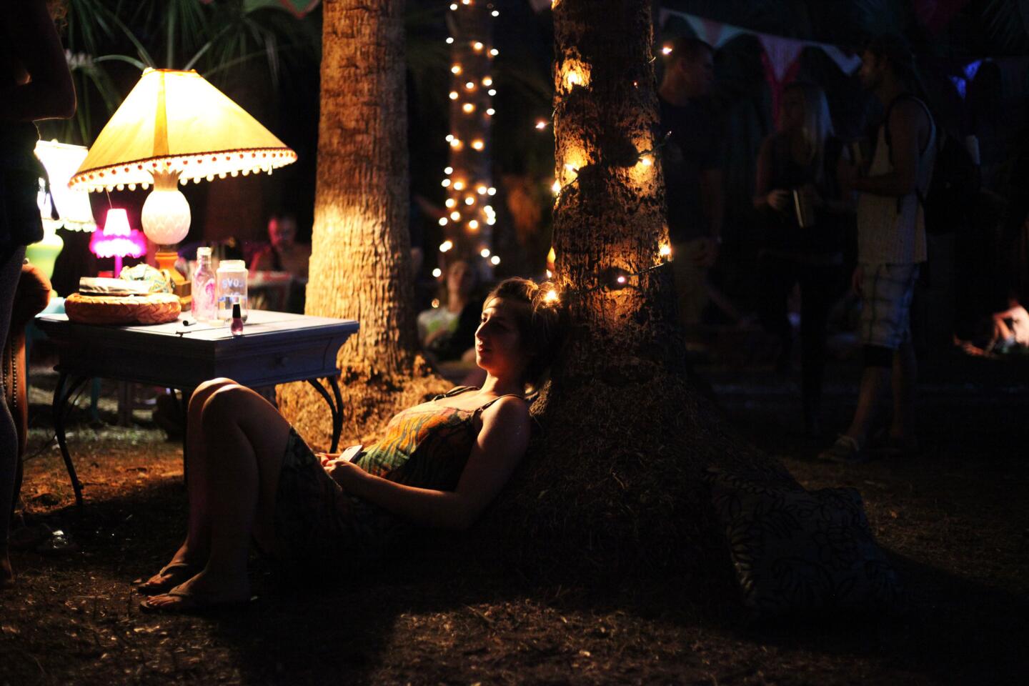 Sam Pope, 22, of Gainesville, sits by a tree inside the tea lounge at Okeechobee Music and Arts Festival on March 2.