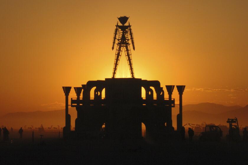 FILE - In this Sept. 2, 2006 file photo, "The Man," a stick figured symbol of the Burning Man art festival, is silhouetted against a morning sunrise in Nevada's Black Rock Desert. The U.S. Bureau of Land Management is recommending attendance be capped at existing levels for the next 10 years at the annual Burning Man counter-culture festival in the desert 100 miles north of Reno. Burning Man organizers had proposed raising the current 80,000 limit as high as 100,000 in coming years. (AP Photo/Ron Lewis, File)