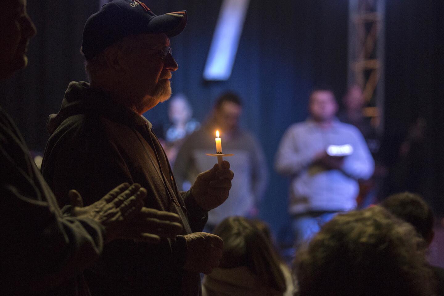 Stan Collins of Benton, second from left, holds a candle during a vigil at Impact Church in Benton, Ky. on Jan. 23, 2018. The vigil was held for victims of the Marshall County High School shooting.