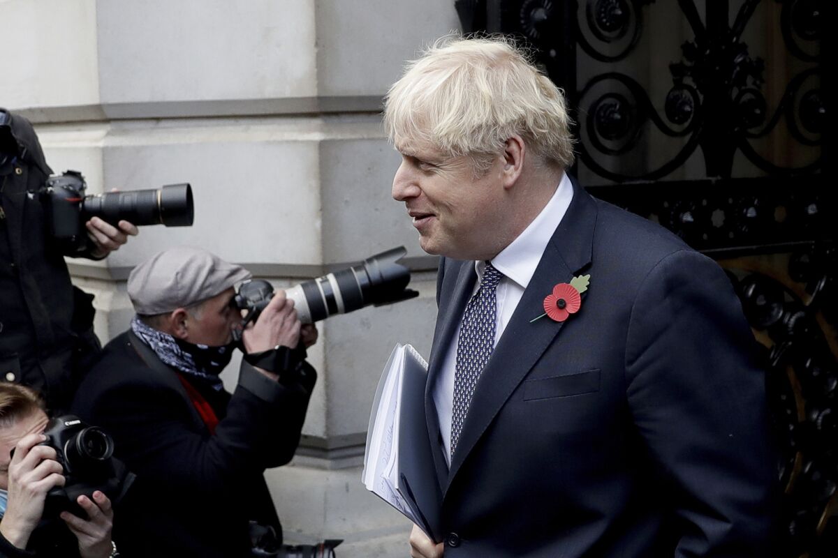British Prime Minister Boris Johnson walks back into Downing Street after attending a weekly cabinet meeting at the Foreign, Commonwealth & Development Office, in London, Tuesday, Nov. 10, 2020. (AP Photo/Matt Dunham)