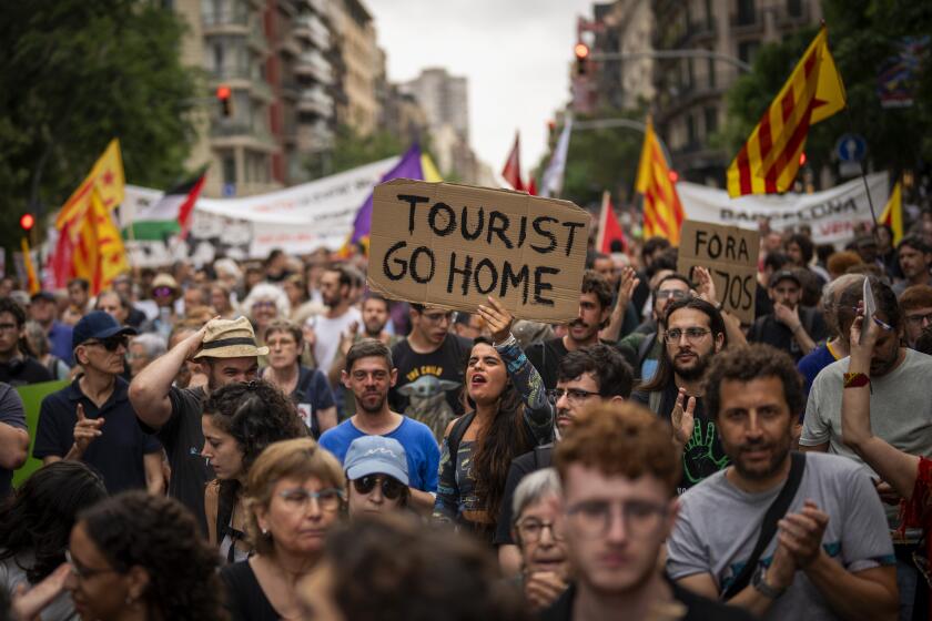 Demonstrators march shouting slogans against the Formula 1 Barcelona Fan Festival in downtown Barcelona, Spain, Wednesday, June 19, 2024. Around 500 Barcelona residents protest against mass tourism during an exhibition of Formula One race cars in the Spanish city. (AP Photo/Emilio Morenatti)