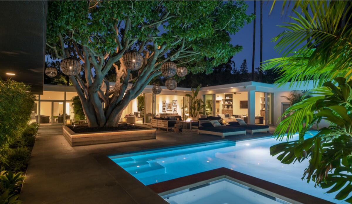 A swimming pool and exterior of a single-story home in Trousdale Estates.