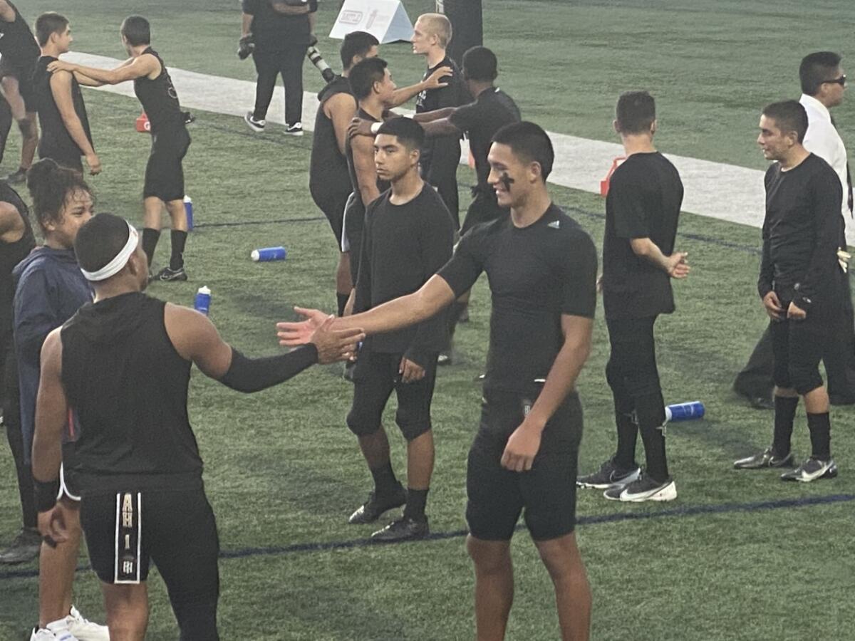 Receiver Tetairoa McMillan shakes hands with quarterback Noah Fifita.