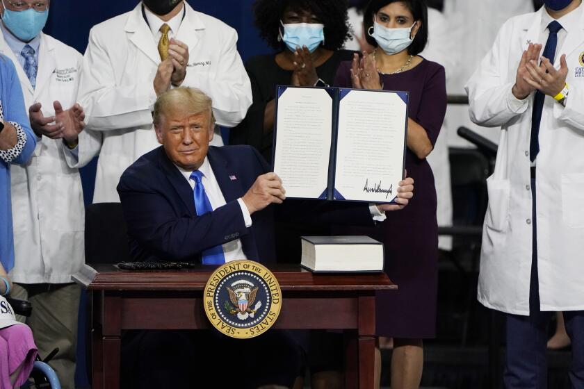 President Donald Trump holds up an executive order after delivering remarks on healthcare at Charlotte Douglas International Airport, Thursday, Sept. 24, 2020, in Charlotte, N.C. (AP Photo/Chris Carlson)