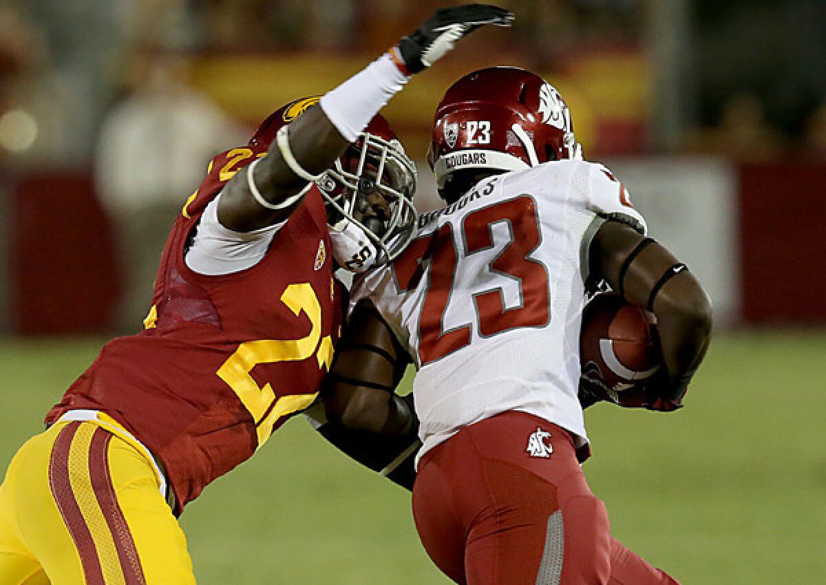 USC safety Leon McQuay, left, tries to strip the ball from Washington State punt returner Leon Brooks, who fumbled it out of bounds in the first quarter of the Trojans' 10-7 loss Saturday.