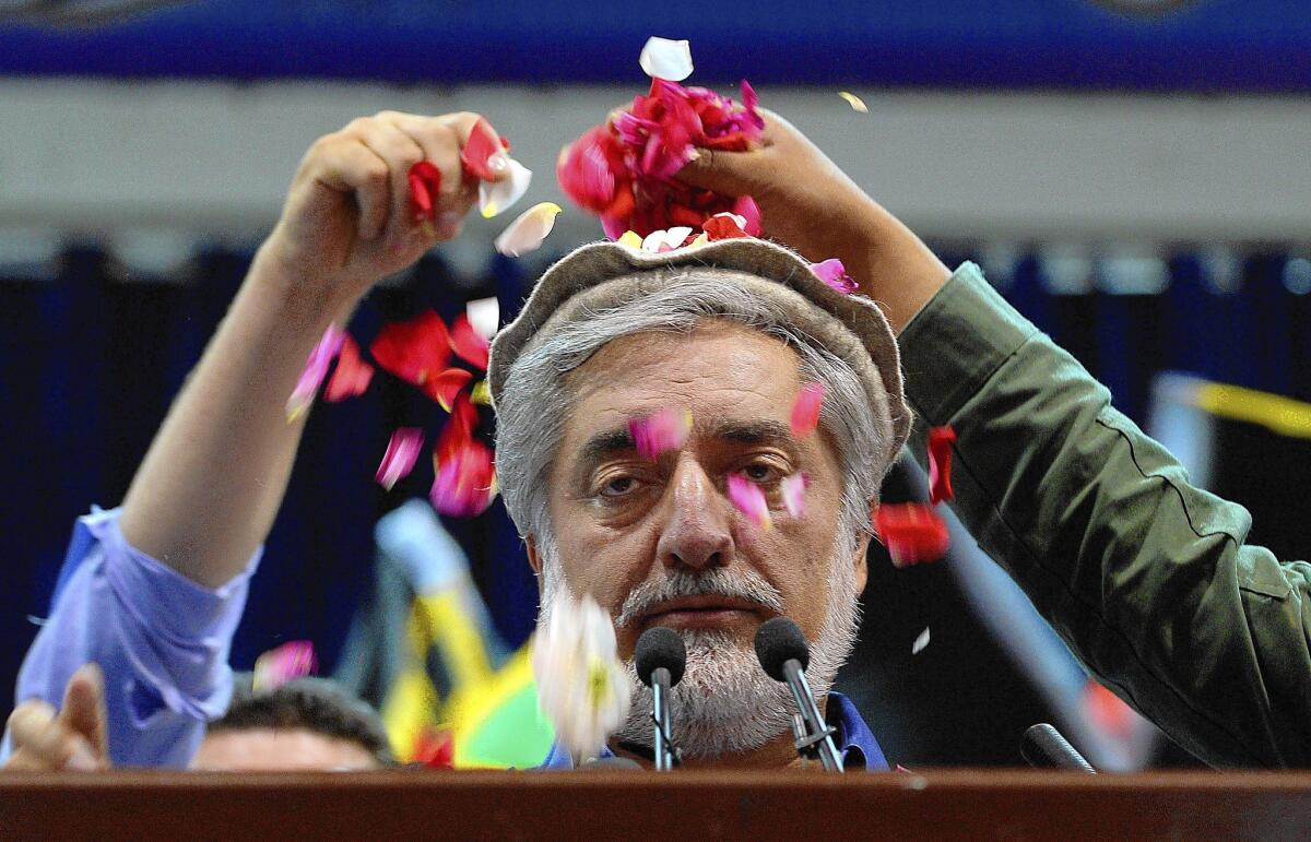 Afghan presidential candidate Abdullah Abdullah is showered with rose petals as he prepares to speak at a rally in Kabul. Abdullah claimed victory in the disputed election, blaming fraud for putting him behind in preliminary results.