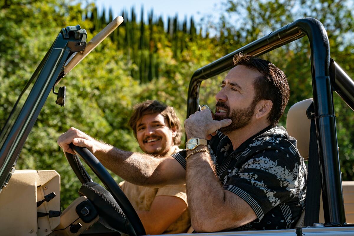 Two men ride in a jeep in the movie in “The Unbearable Weight of Massive Talent.”