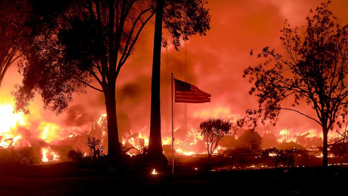 An American flag still flies as as structures burn from a wildfire Oct. 9 in Coffey Park, Calif.