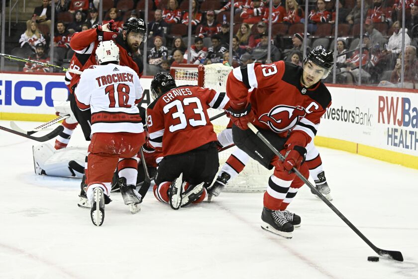 FILE - New Jersey Devils center Nico Hischier (13) skates away with the puck during the second period of an NHL hockey game against the Carolina Hurricanes, Saturday, April 23, 2022, in Newark, N.J. Coming into the 2022-2023 season, the Devils have missed the playoffs the last four years. (AP Photo/Bill Kostroun, File)
