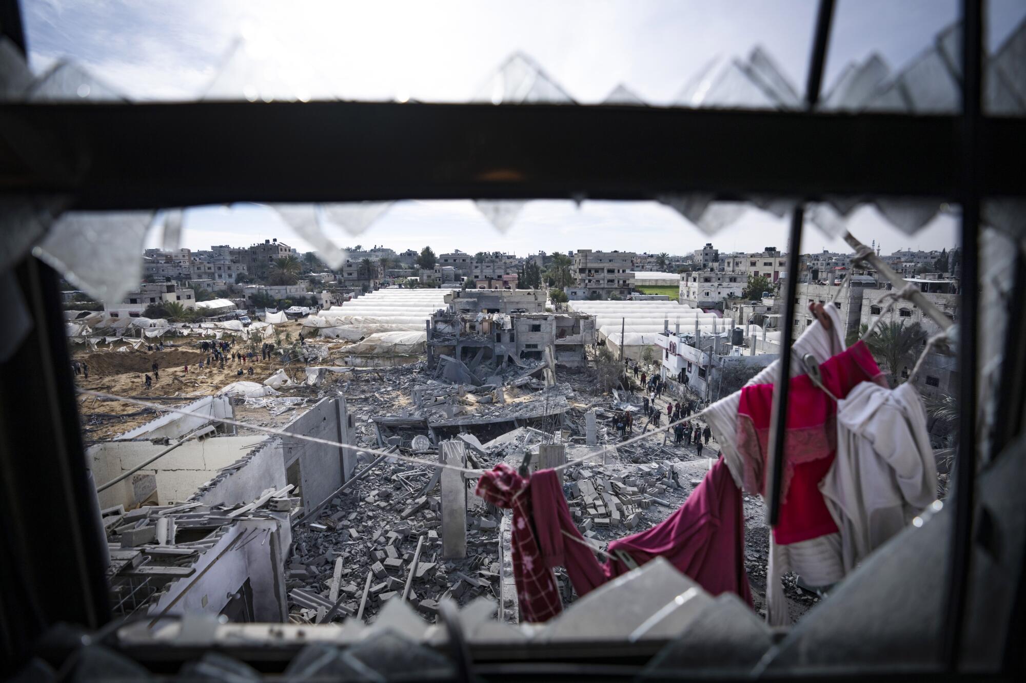 Palestinians inspect the damage to residential buildings in Rafah, in the southern Gaza Strip