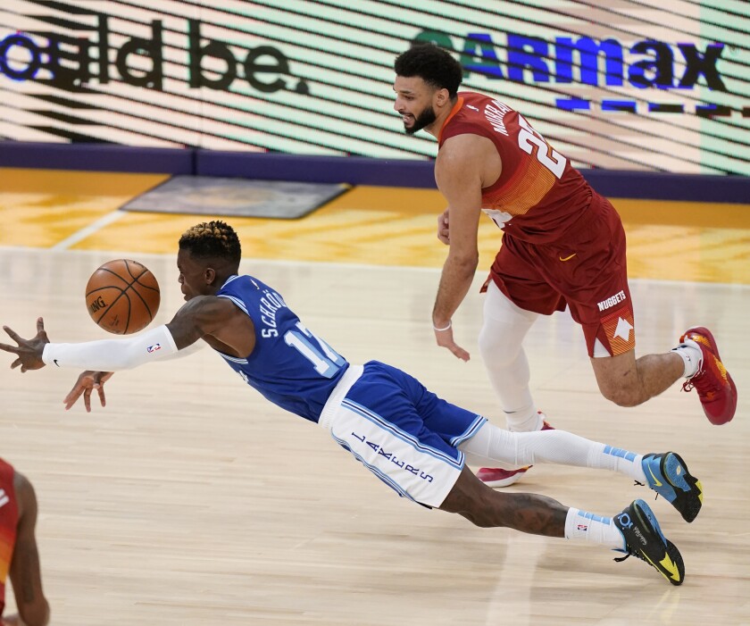 Lakers guard Dennis Schroder dives for a loose ball after knocking it away from Nuggets guard Jamal Murray.