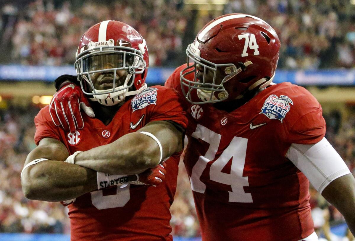Alabama running back Bo Scarbrough (9) celebrates with offensive lineman Cam Robinson (74) after scoring a touchdown against Washington during the first half of the Peach Bowl on Dec. 31, 2016.