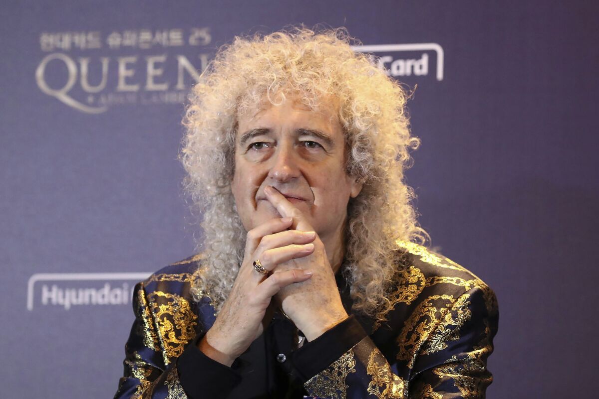 Brian May of Queen clasps his hands in front of his mouth